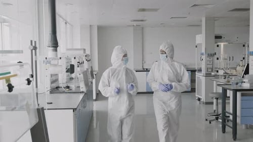 Scientists Walking and Talking in Modern Laboratory Setting