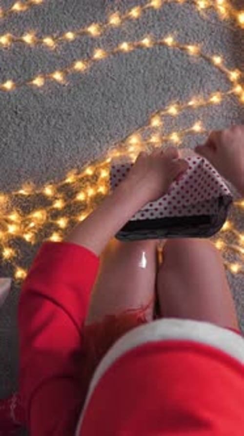 Young Woman Wrapping Christmas Present at Home