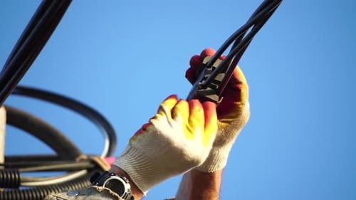 Electrician Working with Electrical Wires on a Sunny Day