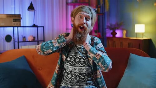 Bearded Man Expressive Hand Gestures on Couch