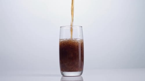 Brown Drink Pouring Into a Glass