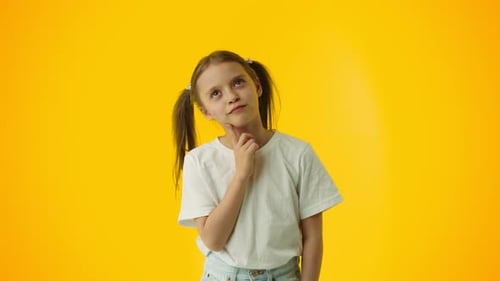 Pensive Young Girl Touching Chin on Yellow Background