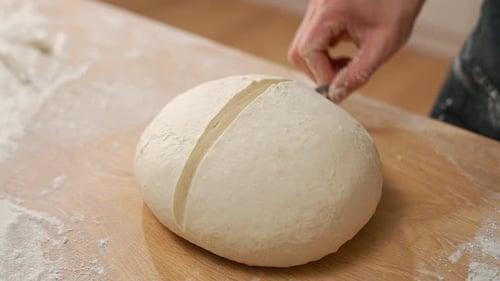 Close Up of Hand Scoring Dough with Knife