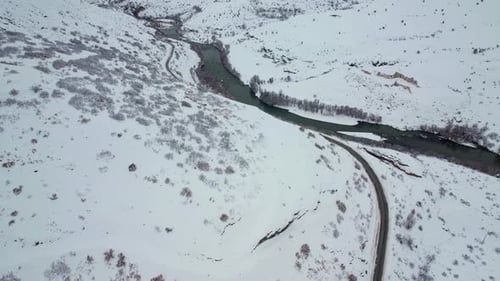 Train Passing Through Snowy Winter Landscape Near River