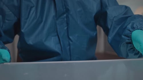 Chemist in Protective Clothing Working with Flammable Liquids