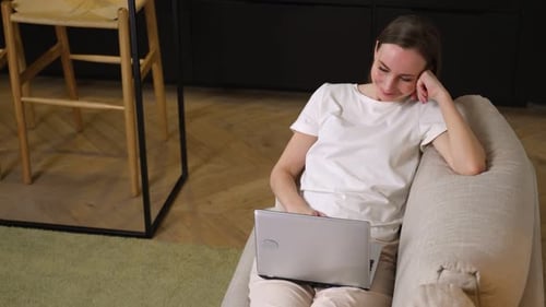 Woman Relaxes with Laptop at Home