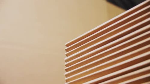 Worker Puts Folded Cardboard Paper Onto Pile in Workshop