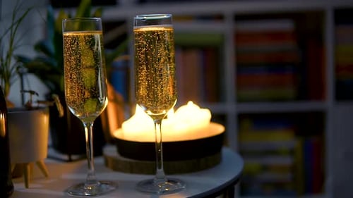 Glasses Of Champagne With Bubbles On The Table With Candlelit Background. close up
