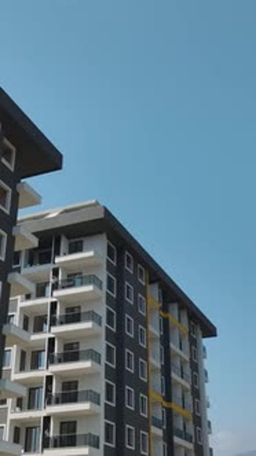 Vertical Video Construction Site of a MultiStory Building Facade Work and Material Loading on Floors