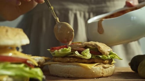 Cook Plentifully Pours Juicy Ranch Sauce Over Burger Drops of Delicious Barbecue Sauce Run Down