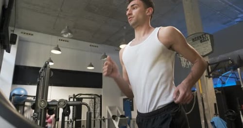 Homem suando enquanto corre em uma esteira na academia