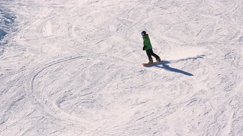 Snowboarder fährt einen verschneiten Berghang hinunter — Winterabenteuerszene