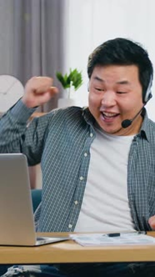 Excited Man Celebrates Success in Home Office Setup