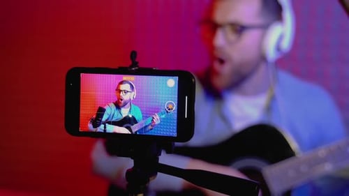 Adult Recording Guitar Playing With Smartphone