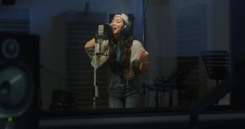 Young Woman Singing in Recording Studio with Microphone