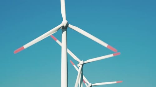 Large rotating wind turbine blades against the blue sky