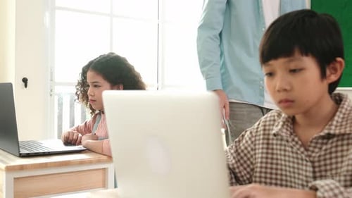 Caucasian teacher helping energetic boy coding engineering prompt. Pedagogy.