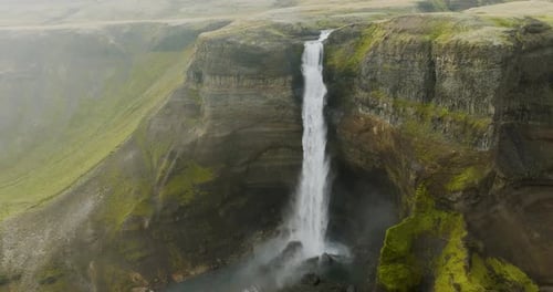 Aerial view of Haifoss waterfall in serene canyon, Iceland.