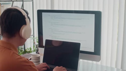 Rear View of Programmer Fixing Bugs in Code on Computer