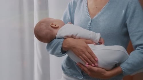 Loving Woman Holds Baby in Her Arms