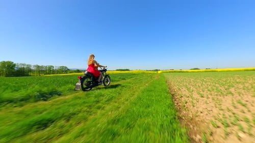 FPV of Woman and Dog Riding a Vintage Motorcycle in the Countryside