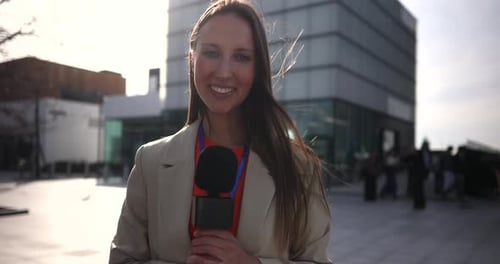 Female News Reporter Holding Microphone Reporting Outdoors