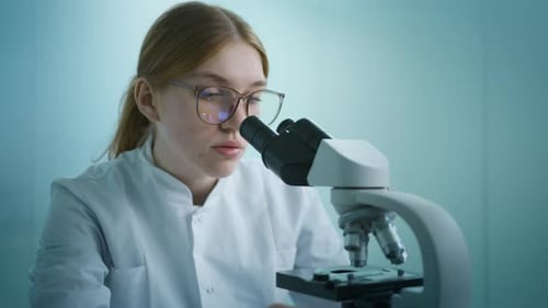 Woman Using Microscope for Research in Laboratory