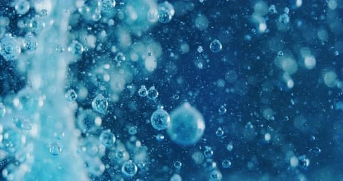 Slow motion macro of micro particles molecules in a liquid are analyzed with microscope for resear