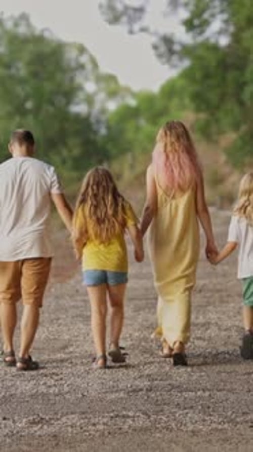 Family Walking Away on a Path Holding Hands