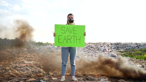 Woman Holding Save Earth Sign at Landfill