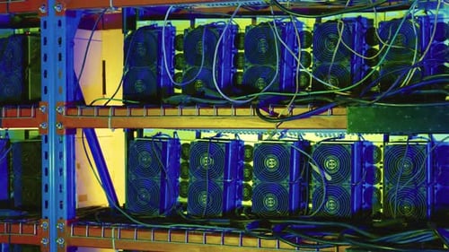 Racks de mineros de bitcoins con cableado denso y ventiladores de refrigeración