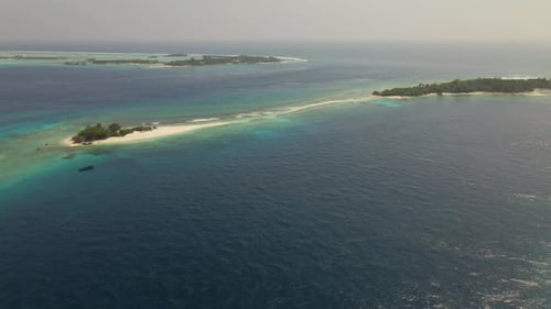 Aerial shot panning over an atoll in the maldives