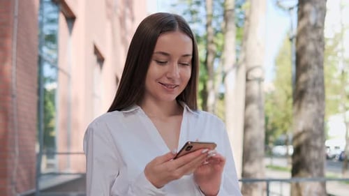 Calm Beautiful Woman Standing Outdoor Using Smartphone Near Office Place