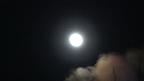 Shining Moon with Drifting Clouds in Dark Sky