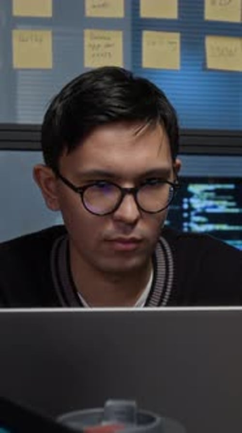 Thoughtful Gen Z Programmer Looking at Laptop Screen Fixing Bugs in Software