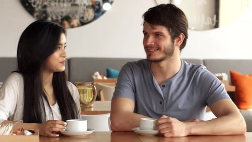 Two Friends Share a Lively Conversation at a Trendy Cafe