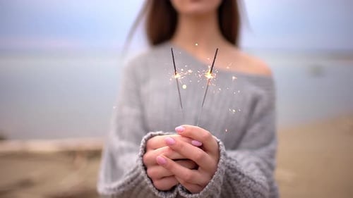 Woman Smiling and Holding Bengal Sparklers Outdoors
