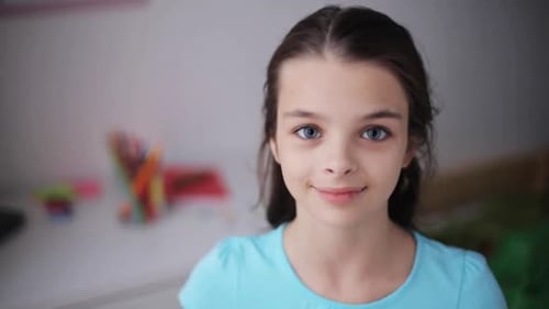 Smiling girl in blue shirt looking at camera