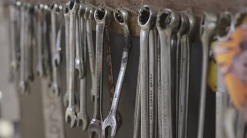 Close Up of Various Sized Wrenches Hanging Organized on a Workshop Wall