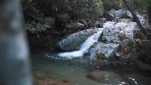 Slow-Motion shot of cascade foamy water falling into natural pools in the river on the jungle