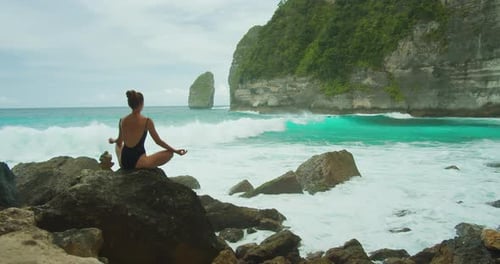 Woman Meditates By the Sea Tembeling Beach with Pristine Ocean Tranquil Girl in Swimsuit Meditating