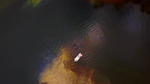 A boat in the river with a swimmer.