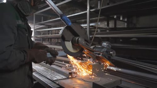 Man Using Metal Saw in Industrial Setting