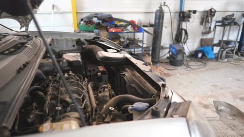 Dolly Shot of Car with Open Hood is Being Fixing in a Auto Service