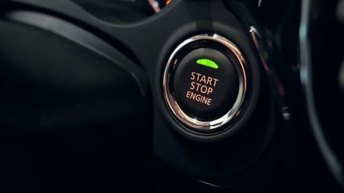 Finger presses start stop engine button in car