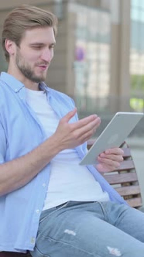 Online Video Chat on Tablet by Man Sitting Outdoor on Bench, Vertical Video