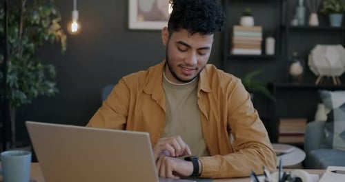 Young Adult Using Smartwatch at Desk in Home Office