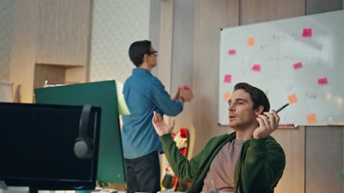 Disappointed Colleagues Talking Together at Office. Eyeglasses Man Tossing Ball Sitting Partner