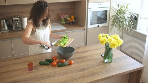 Woman Prepares a Healthy Salad in Kitchen