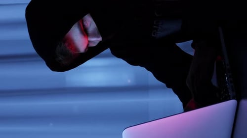 Hacker masculin confiant regardant l'écran d'un ordinateur portable.